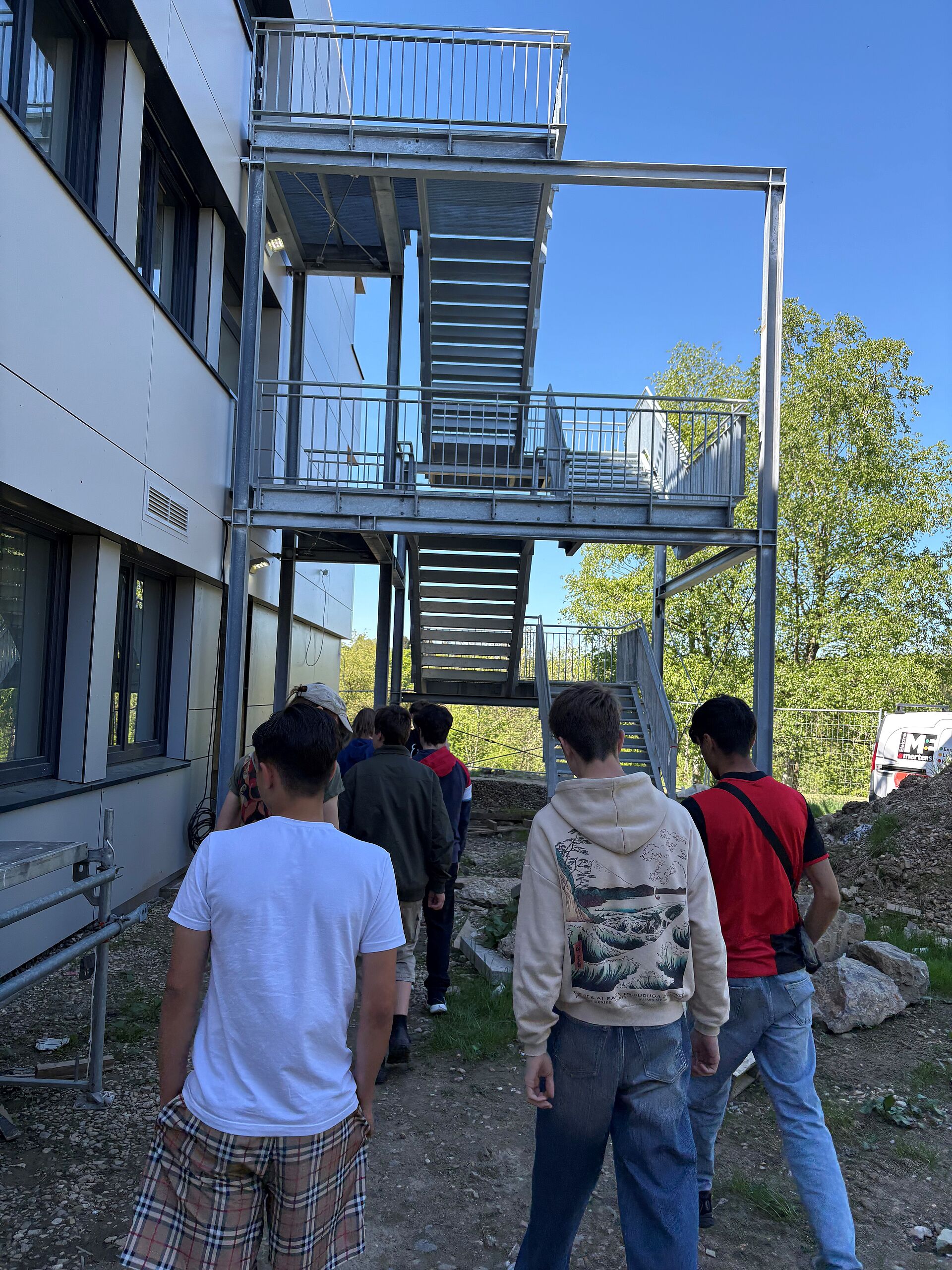 Drei Leute vor einer Stahltreppe.